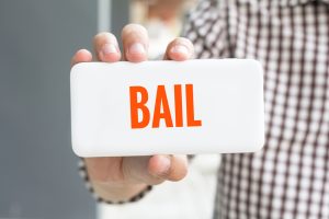 Man,Hand,Showing,Bail,Word,Phone,With,Blur,Business,Man