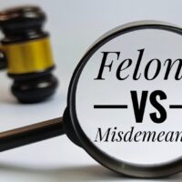 FelonyVsMisdemeanorTextSeenThroughMagnifyingGlassWithBlurred