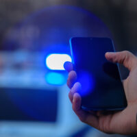 HoldingSmartphoneAndPoliceCarBackground