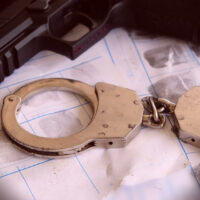 CrimeAndViolenceConceptgunAndPoliceHandcuffsOnFingerprintsCrime